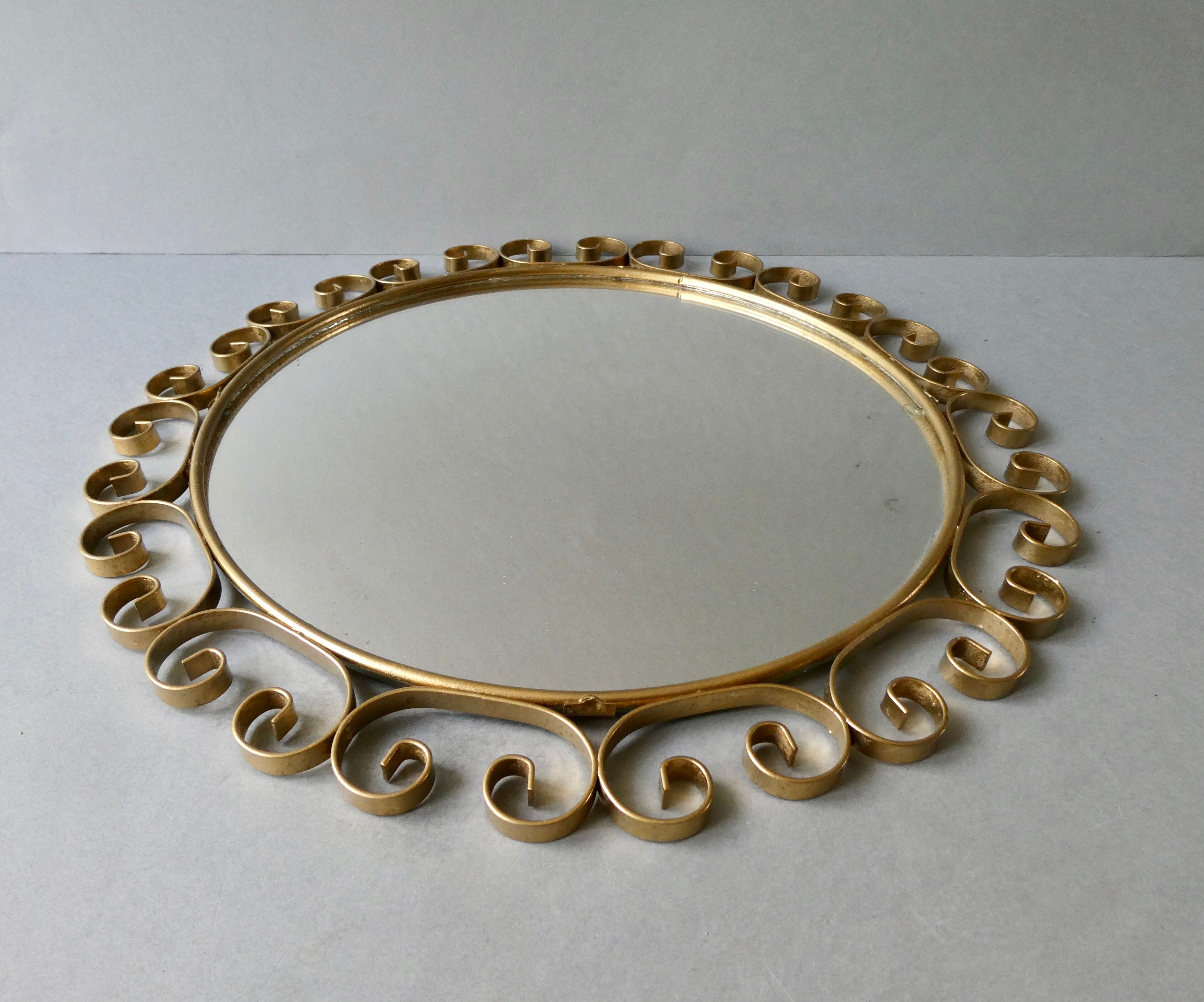 Round mirror with golden metal arabesques