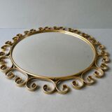 Round mirror with golden metal arabesques