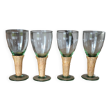 Four stemmed glasses surrounded by rattan.