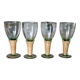 Four stemmed glasses surrounded by rattan.