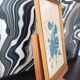 Decorative table with vintage blue flowers in a golden frame.