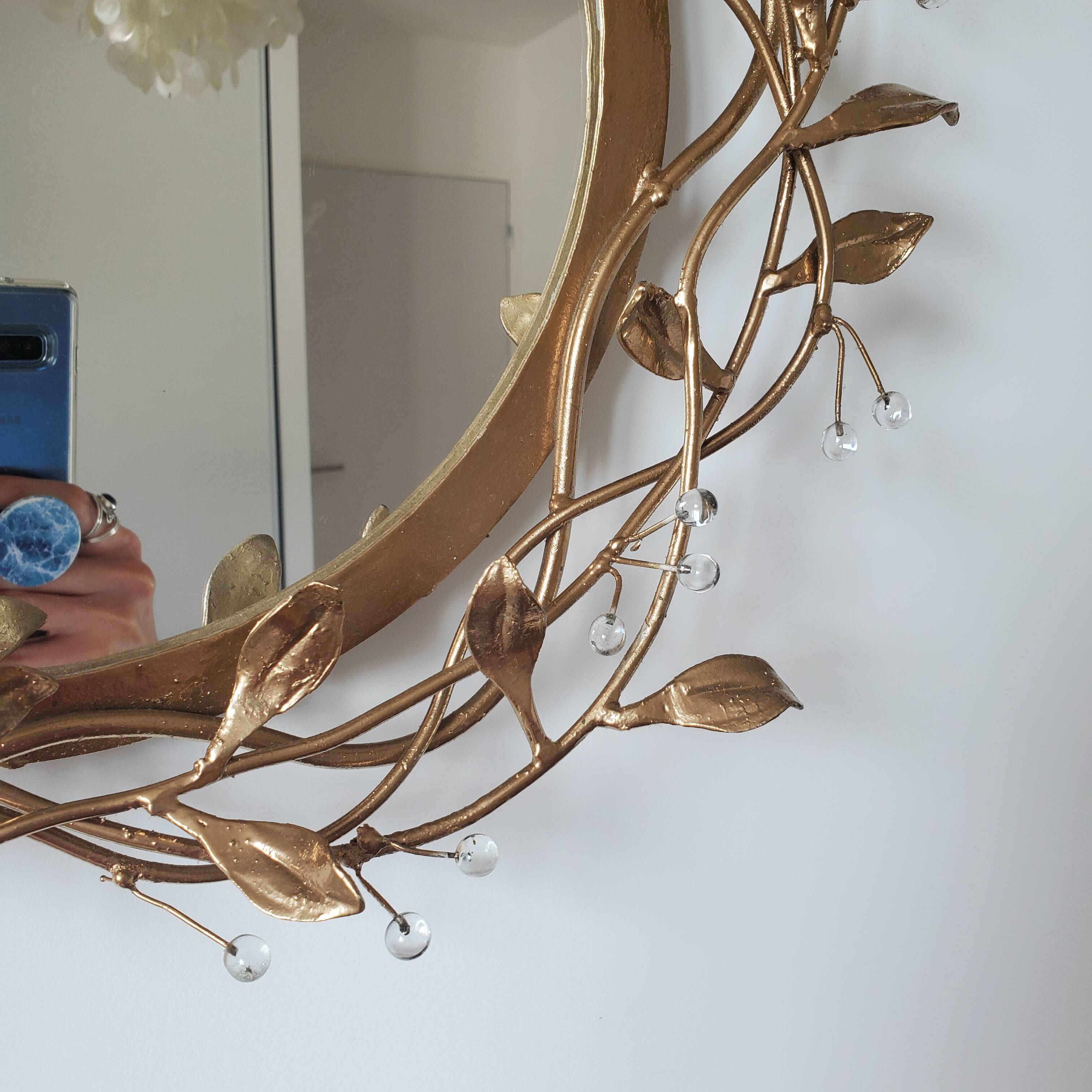 Round mirror in gilded wrought iron and leaves