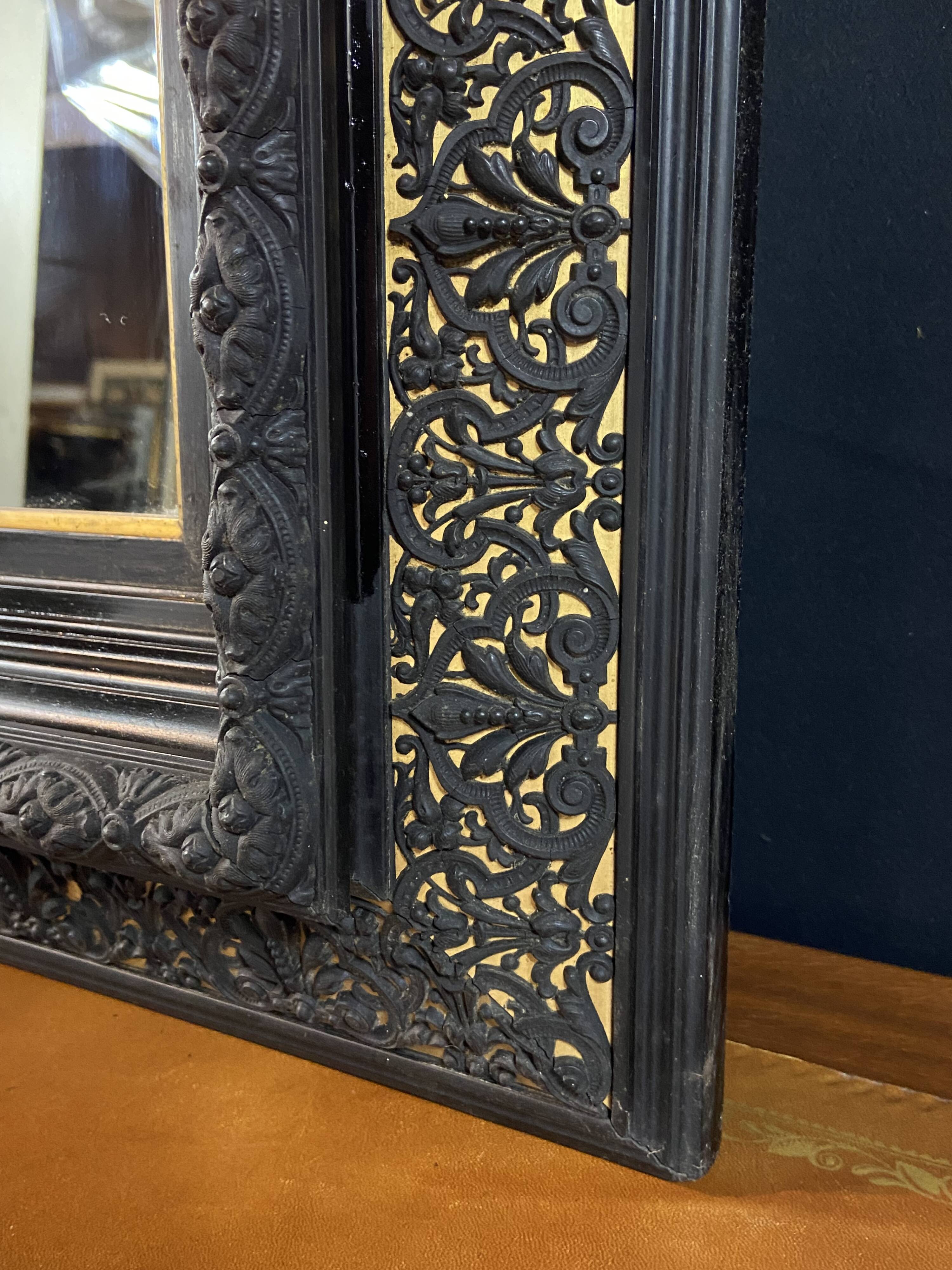 19th-century mirror Napoleon III in blackened wood on a gold background.