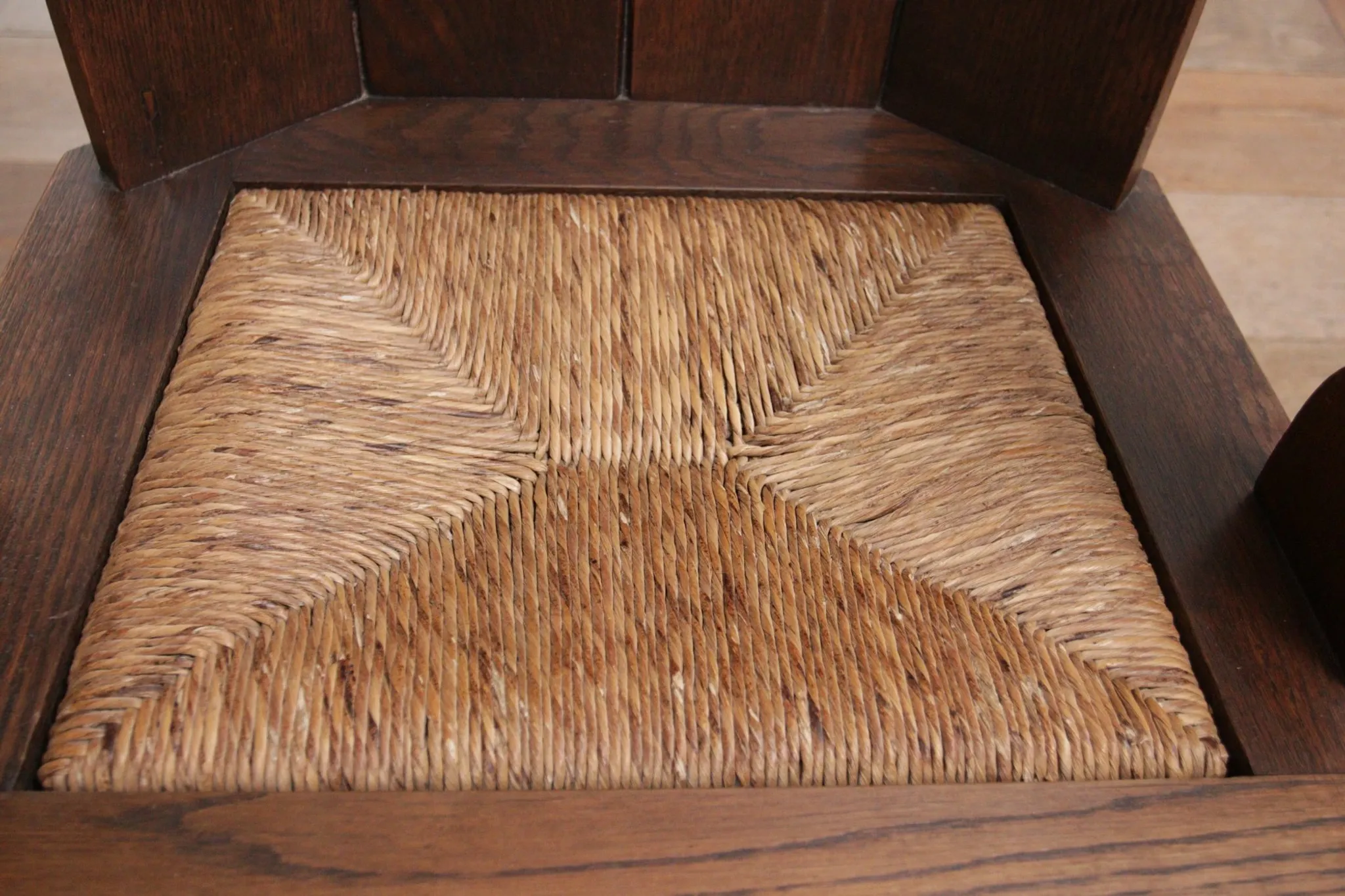 Pair of brutalist oak lounge chairs with rush seats, circa 1935