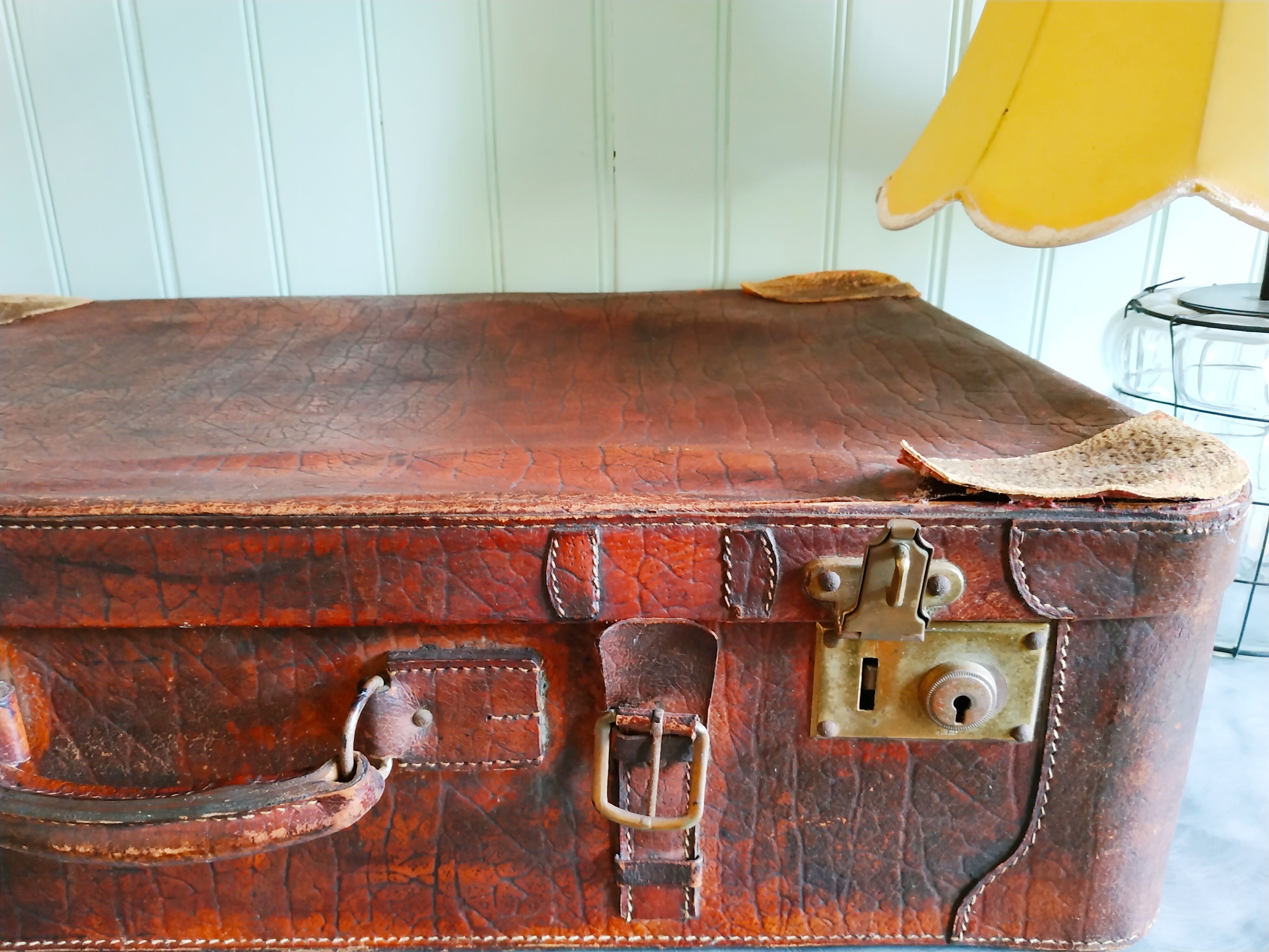 Old cardboard suitcase covered with patinated leather