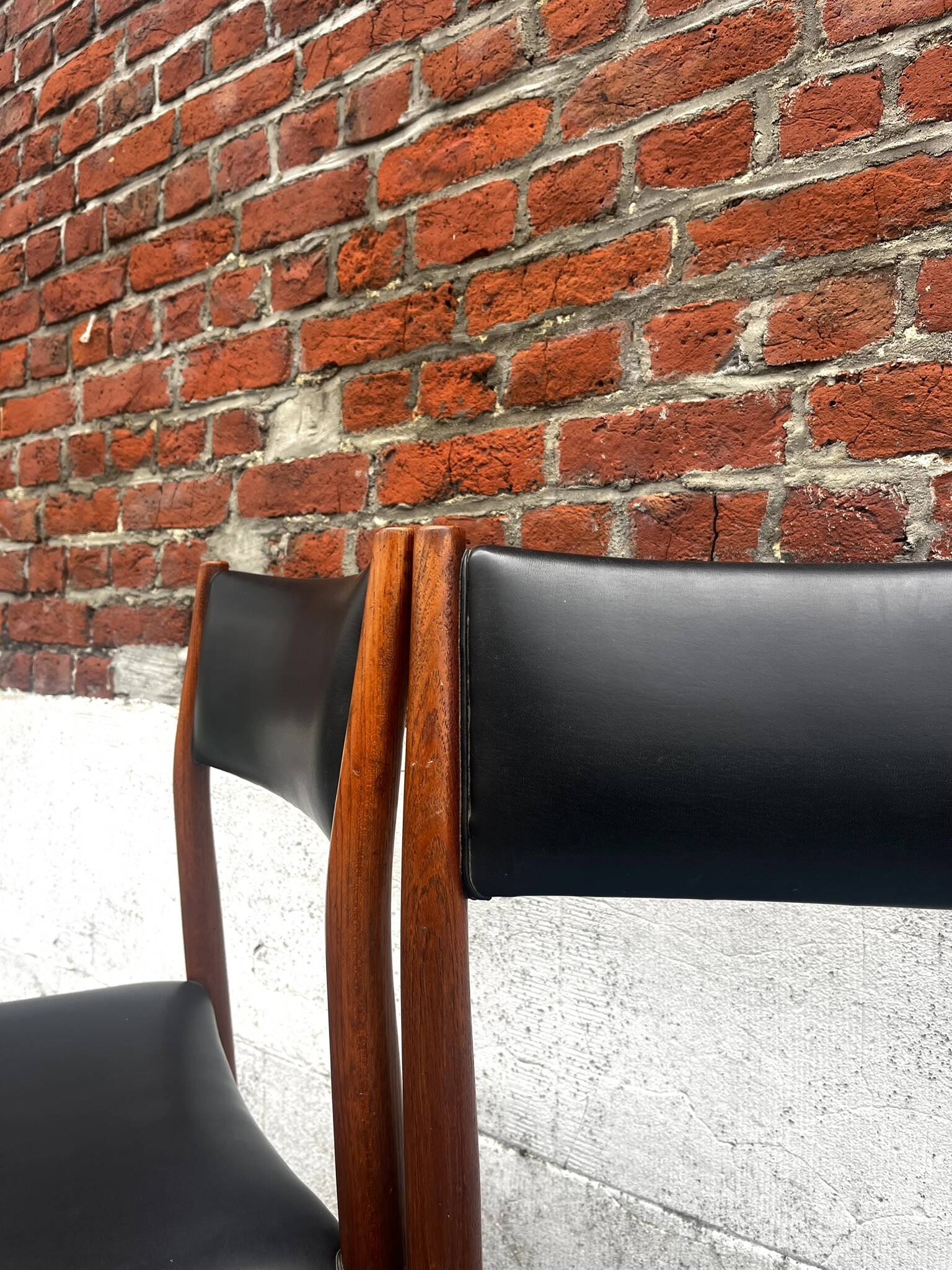 Set of 2 vintage Scandinavian chairs in wood and black faux leather.