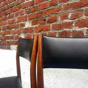 Set of 2 vintage Scandinavian chairs in wood and black faux leather.