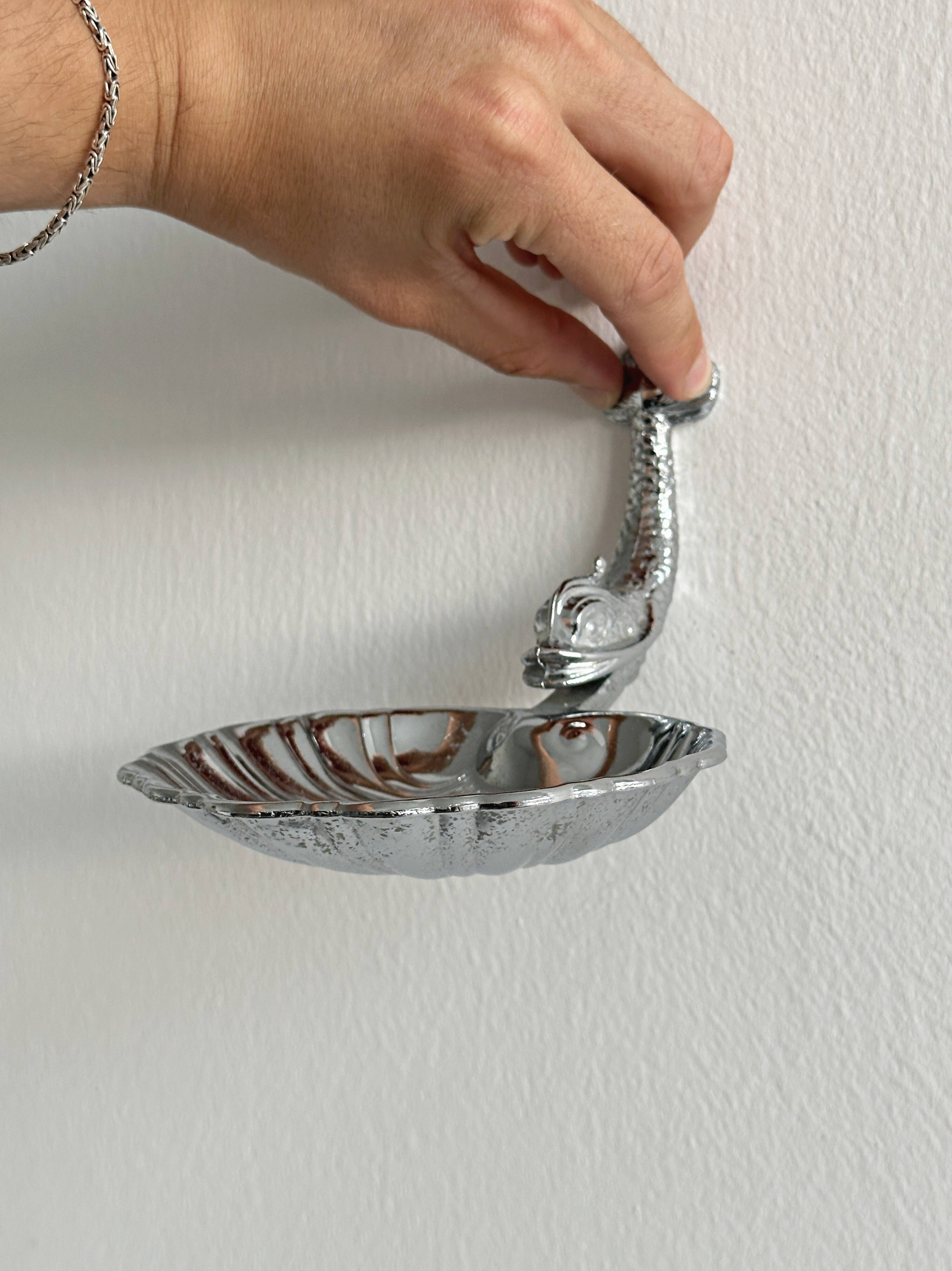 Soap dish, shell-shaped lightweight metal catchall.