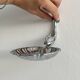 Soap dish, shell-shaped lightweight metal catchall.