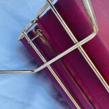 Vintage magazine rack in red skai with gold metal frame and plastic handle