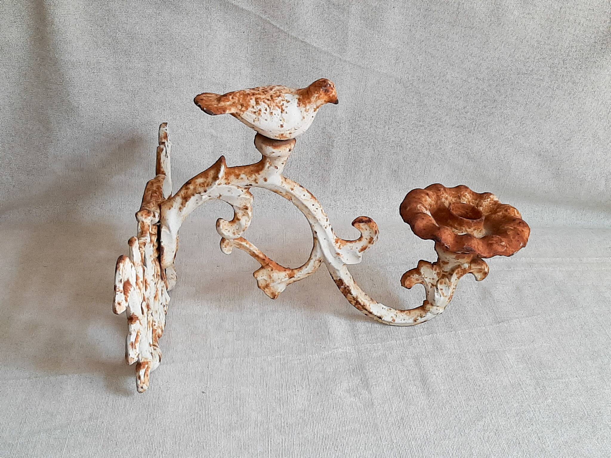 Wall lamp in antique cast iron with bird and scroll decorations.