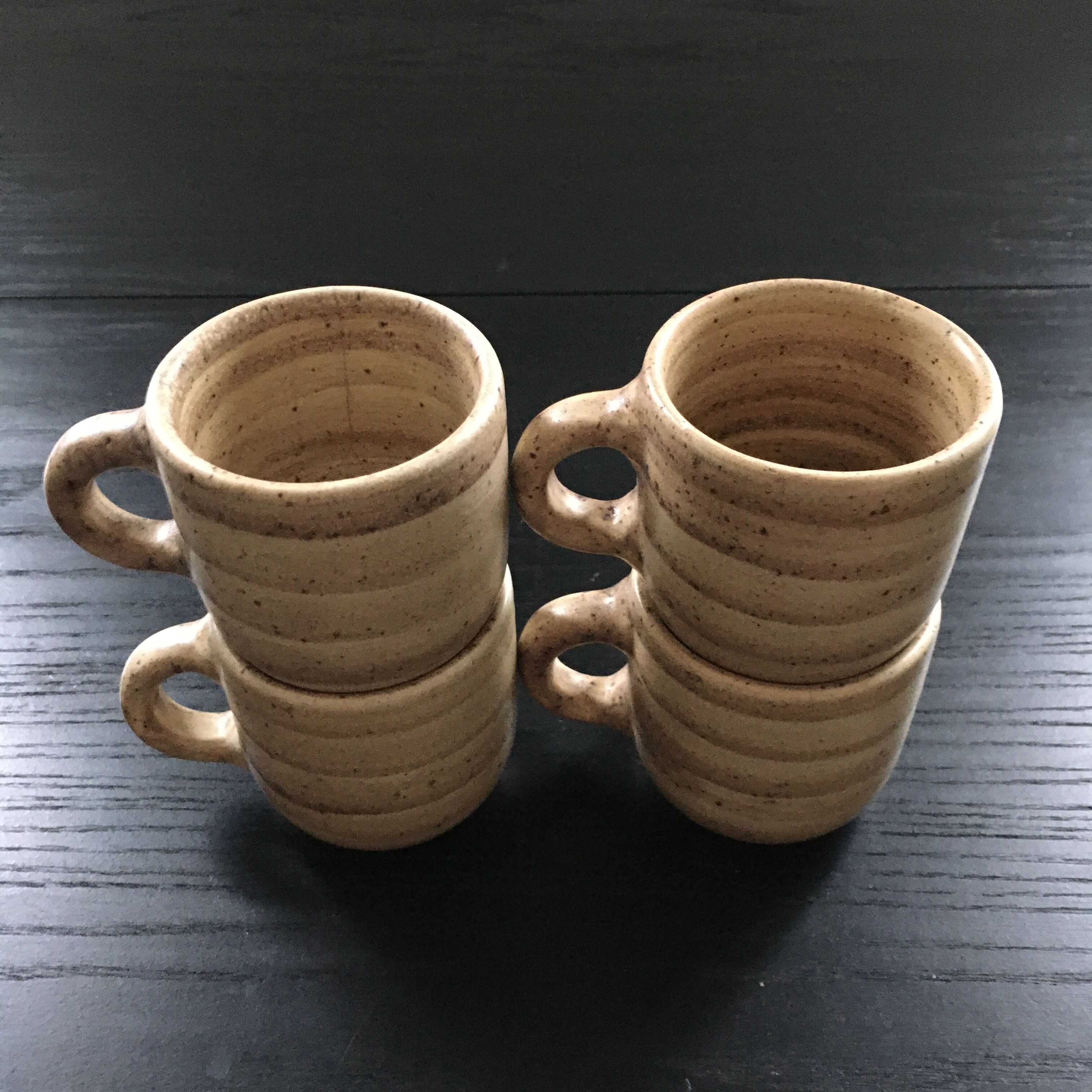 Set of 4 beige stoneware mugs.