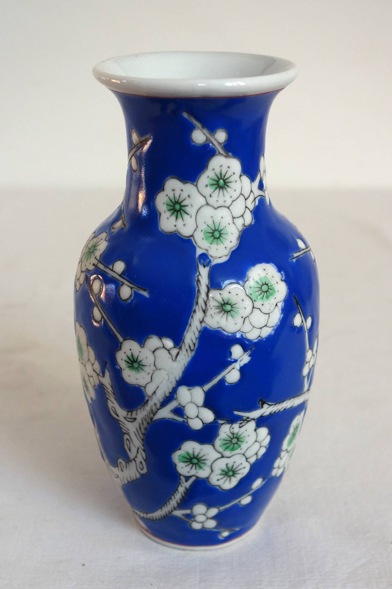 Old blue vase with vintage porcelain cherry blossoms