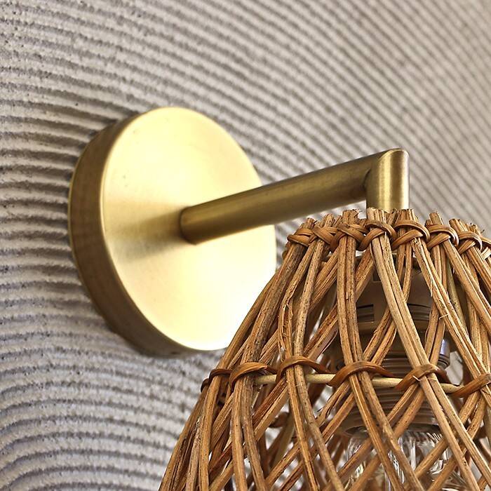 Golden bohemian wall lamp in woven rattan