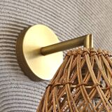Golden bohemian wall lamp in woven rattan