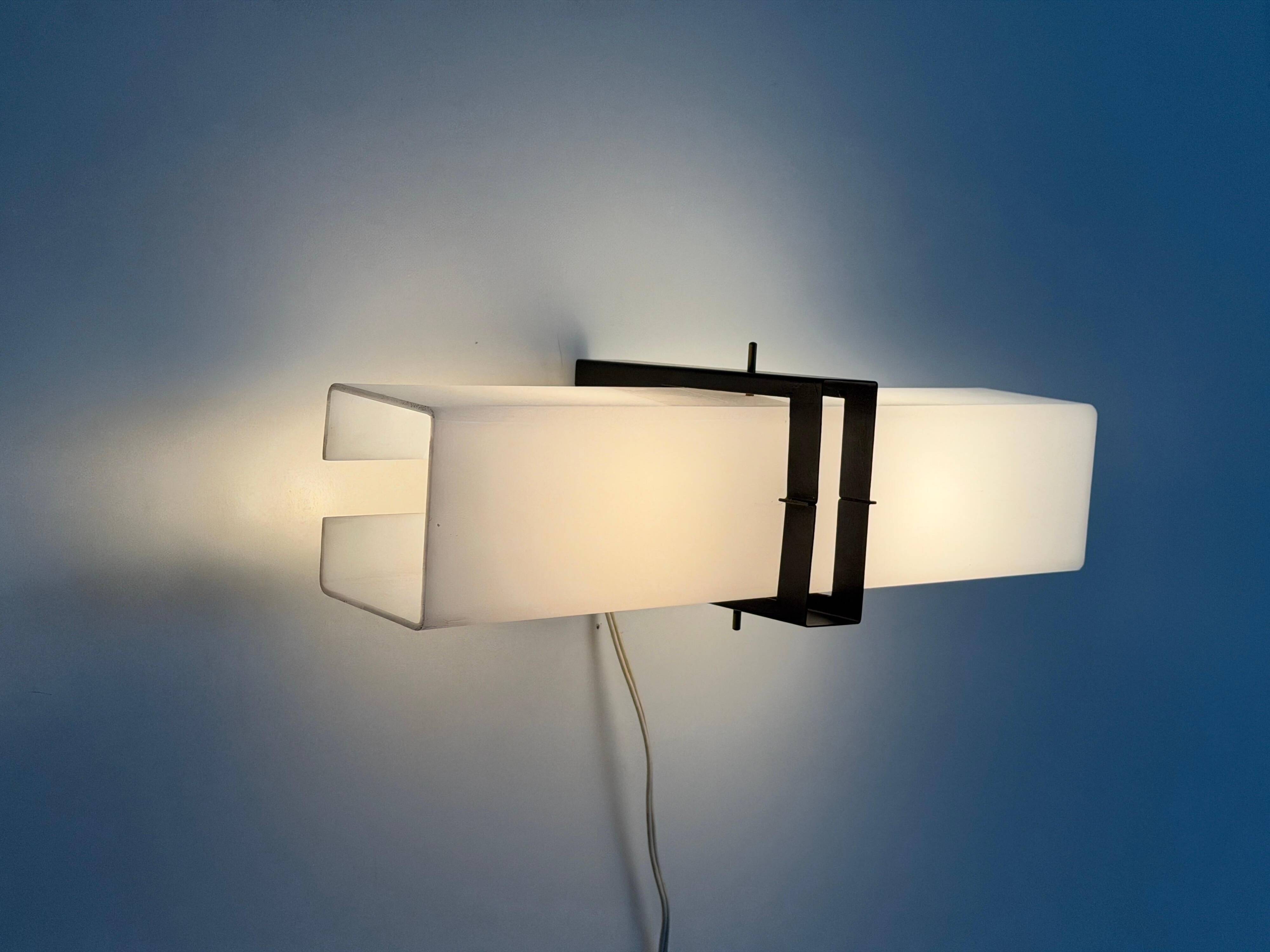 Simple white plexiglass wall light with a black metal frame, 1970s, Germany.