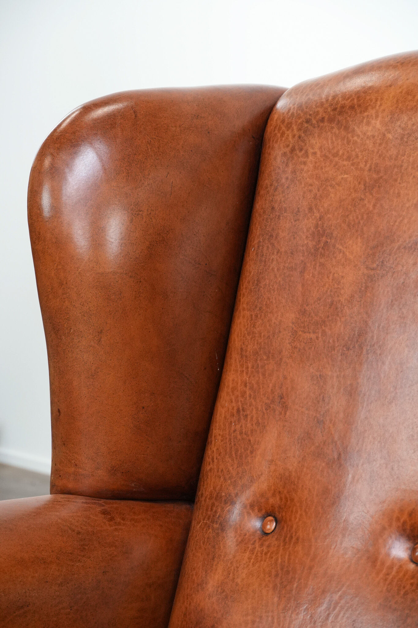 Wingback chair made of sheep leather with black piping in good condition