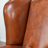Wingback chair made of sheep leather with black piping in good condition