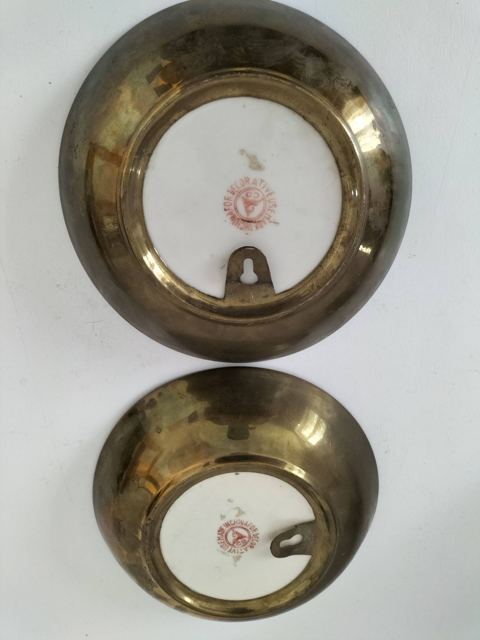 A pair of vintage Chinese decorative plates with floral designs on a yellow background.