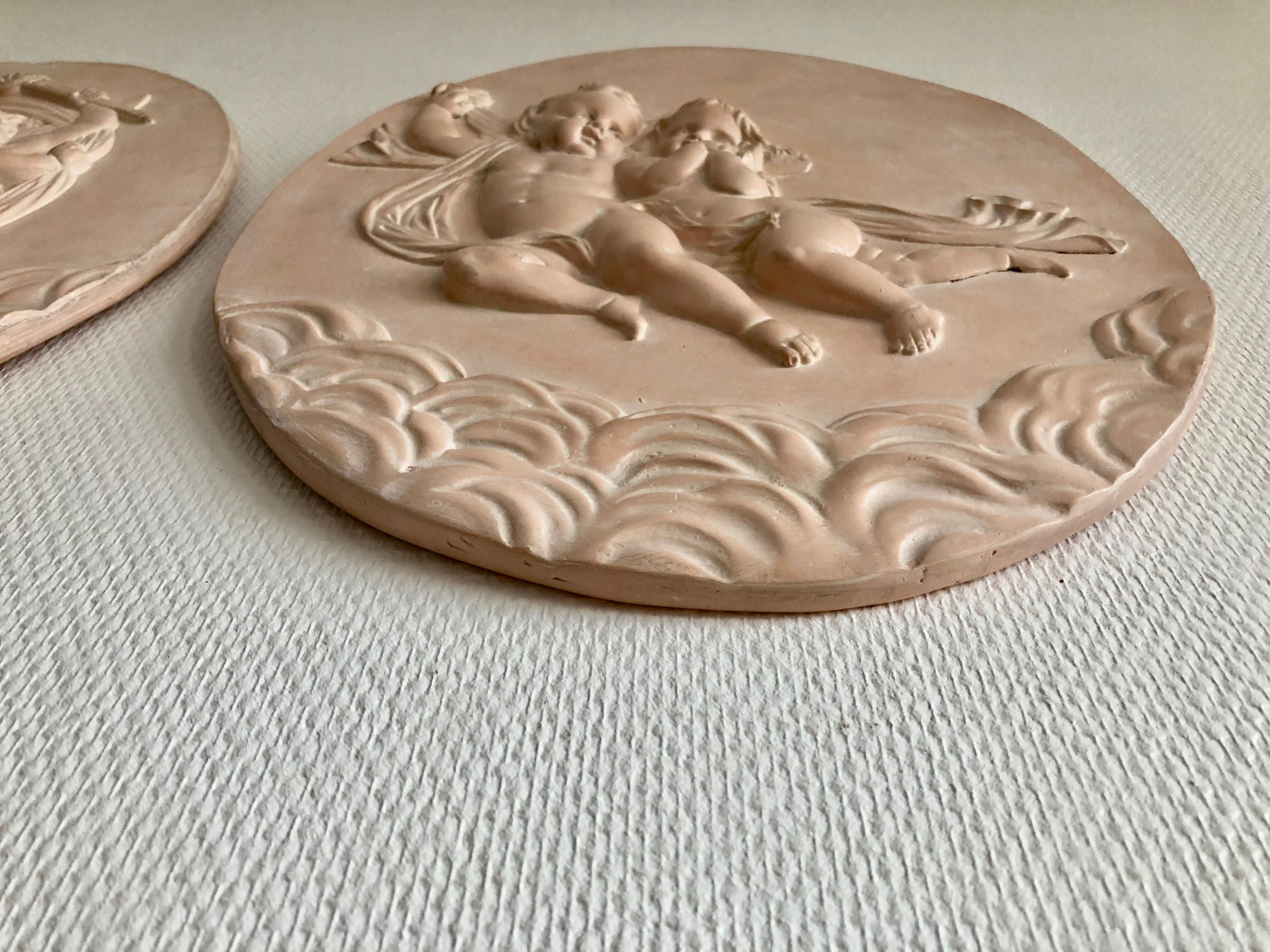 Pair of putti medallions