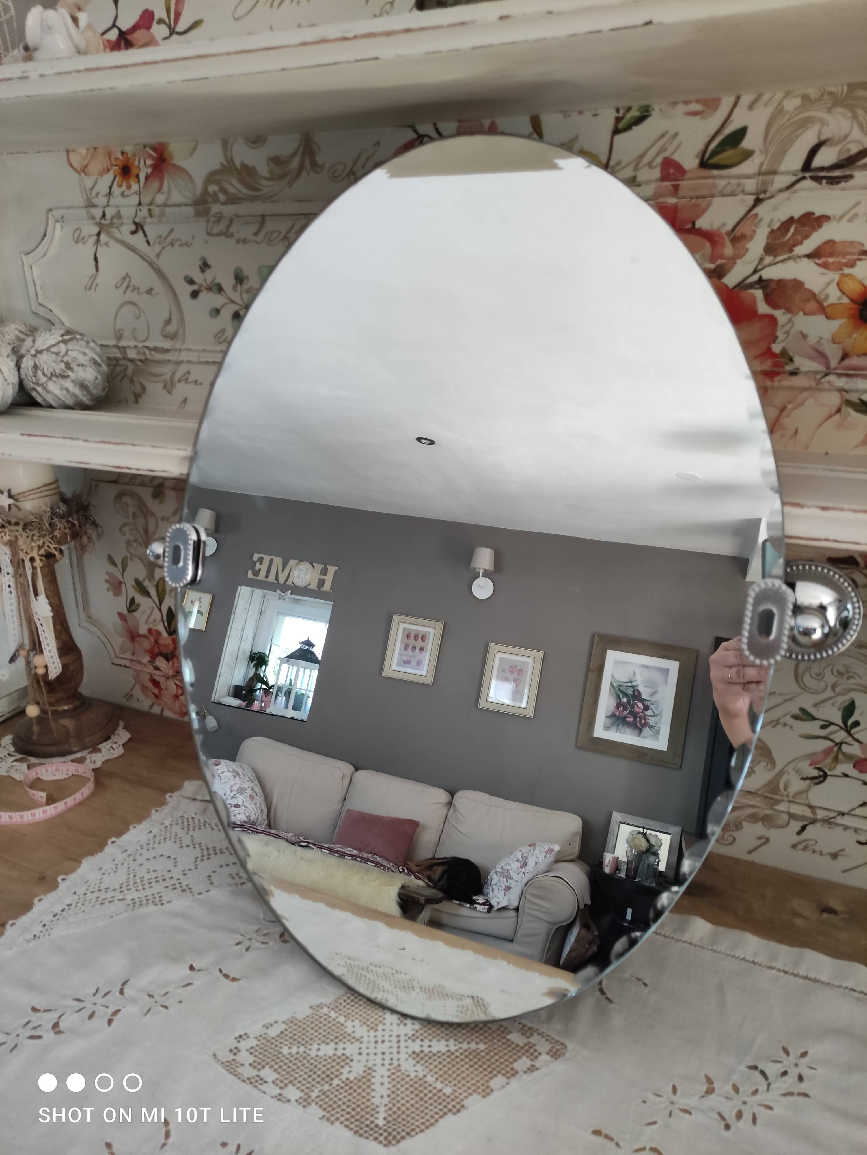 Miroir ovale biseauté vintage années 70 avec ses accroches murales en métal couleur argent