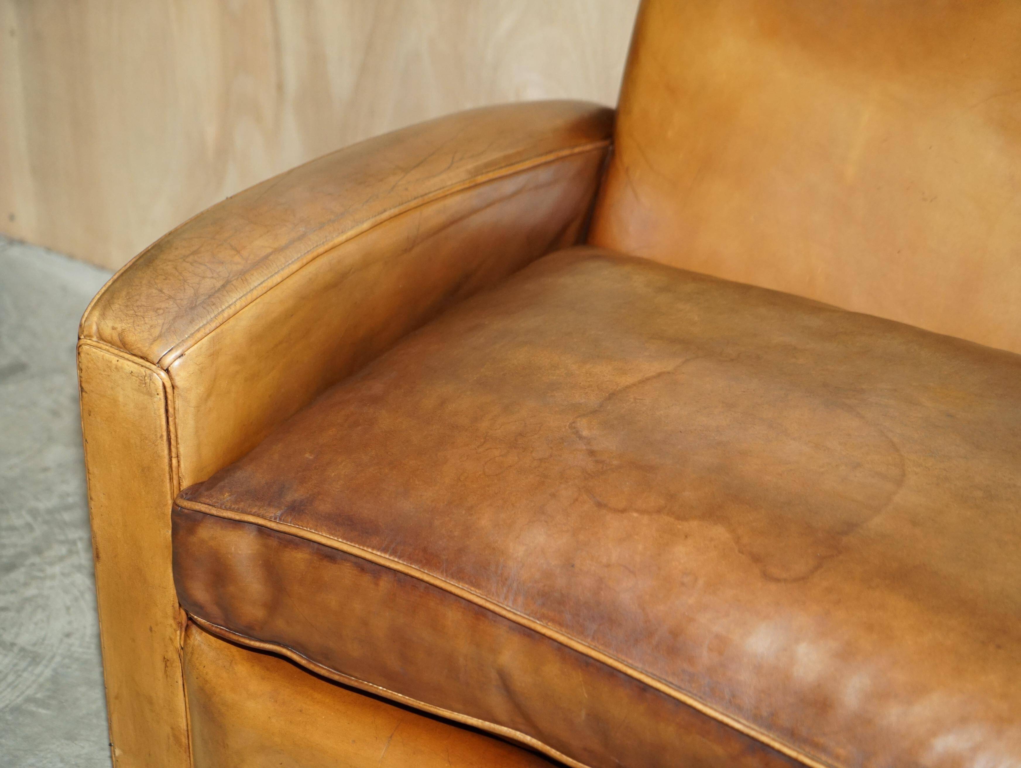 Three-seater Art Deco style leather sofa with feather cushions.