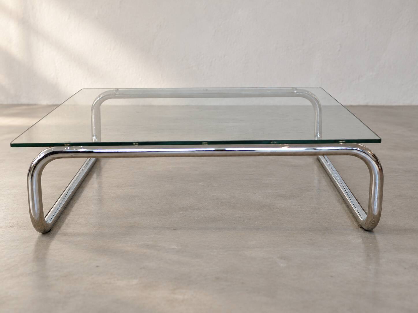 Coffee table in chrome with a glass top.
