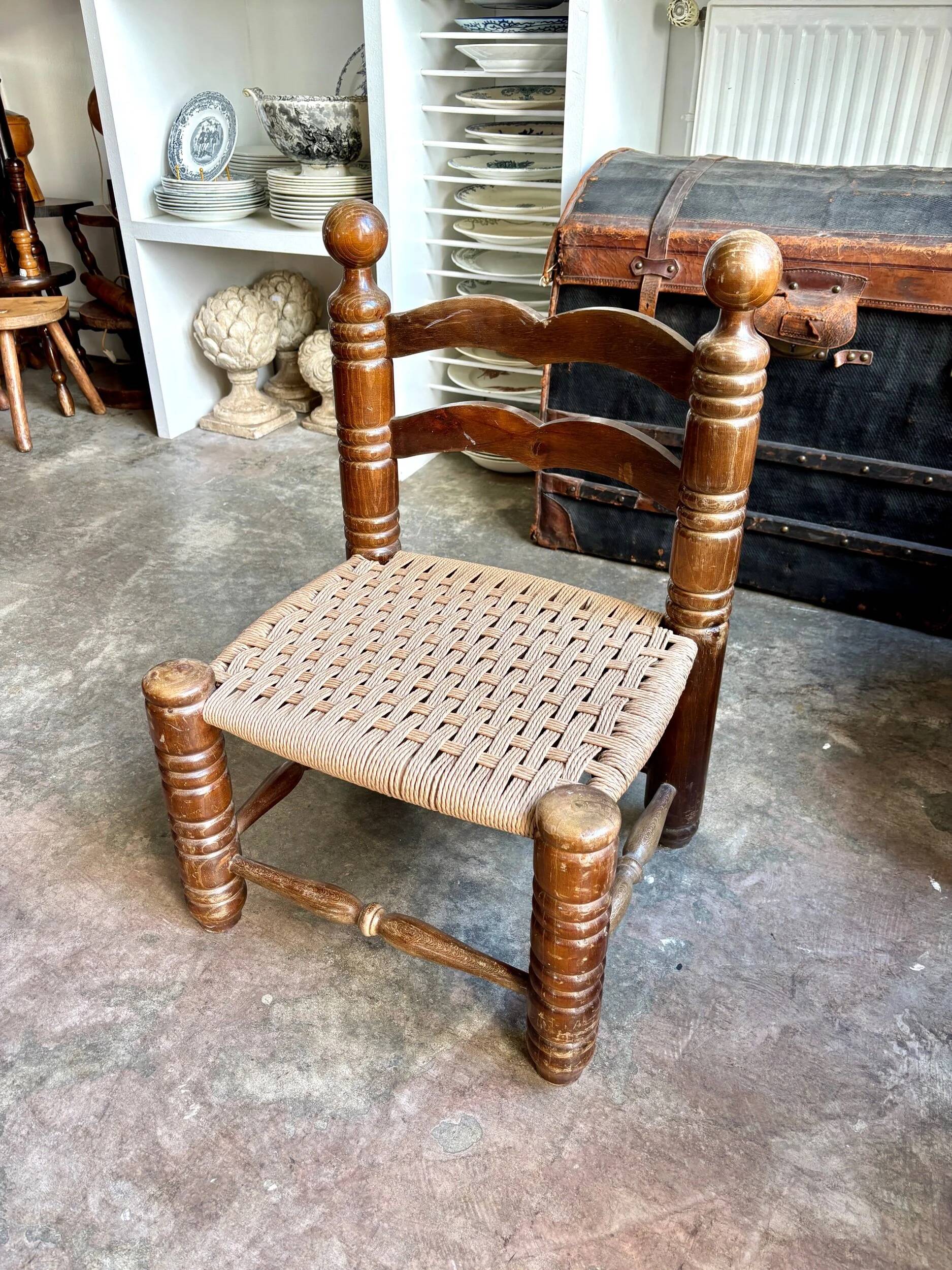 Low chair in dark wood and woven Danish cord attributed to Charles Dudouyt.