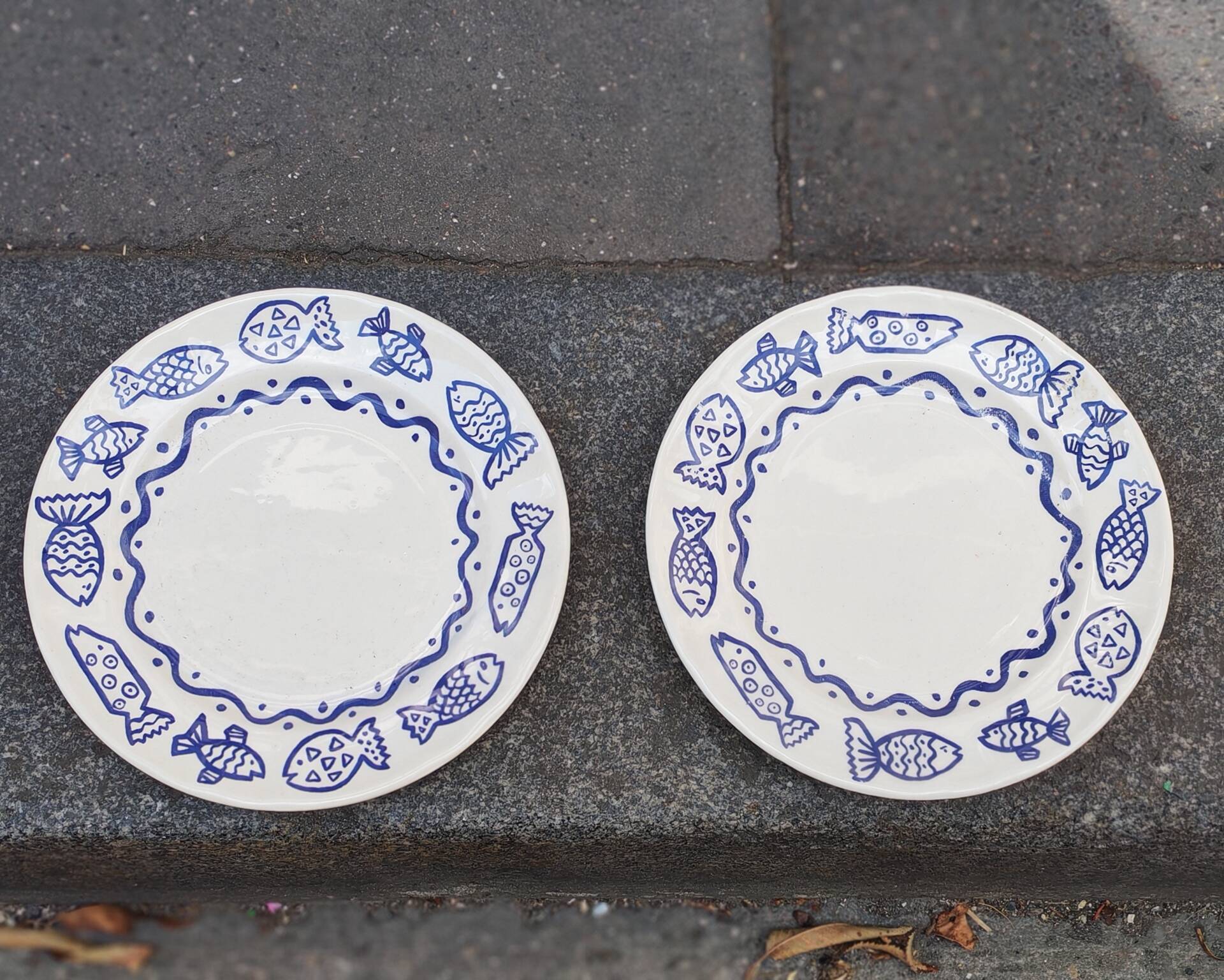 Pair of Castellania plates from Italy with blue fish decoration.