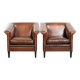 Ensemble de deux fauteuils en peau de mouton au design Art Déco avec passepoil noir.
