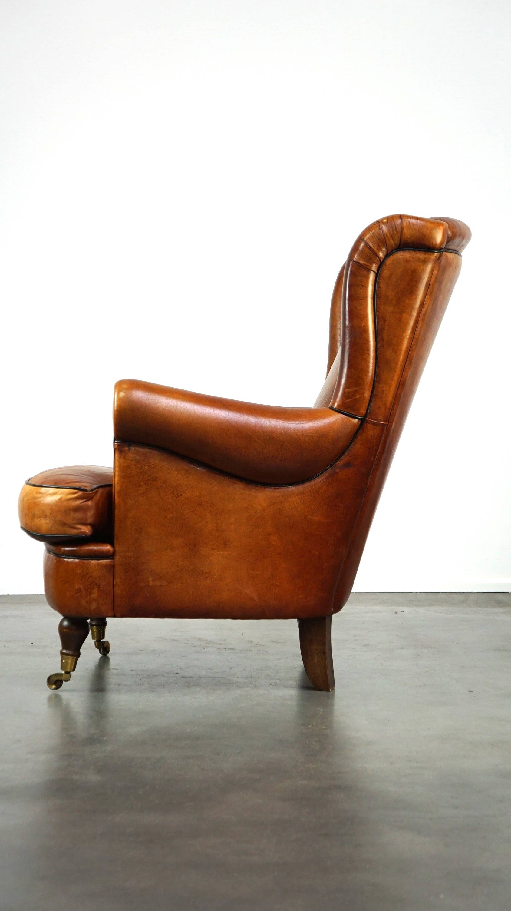Subtle and well-maintained sheep leather armchair on brass front wheels