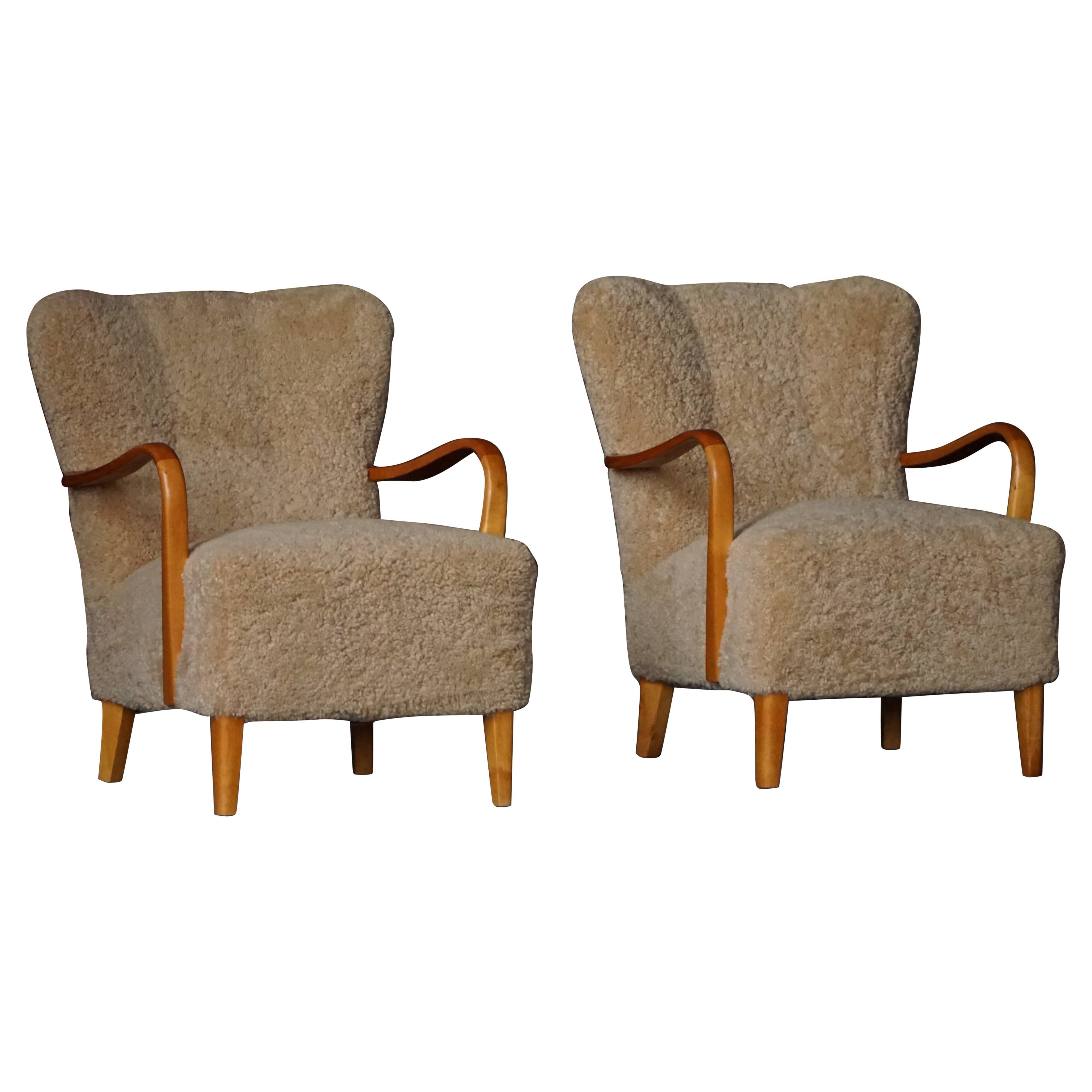 Pair of Mid Century Modern Swedish lounge chairs in birch and lamb's wool, 1960s.