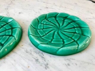 Duo of green slip bottle coasters signed marjac bauzil 50s