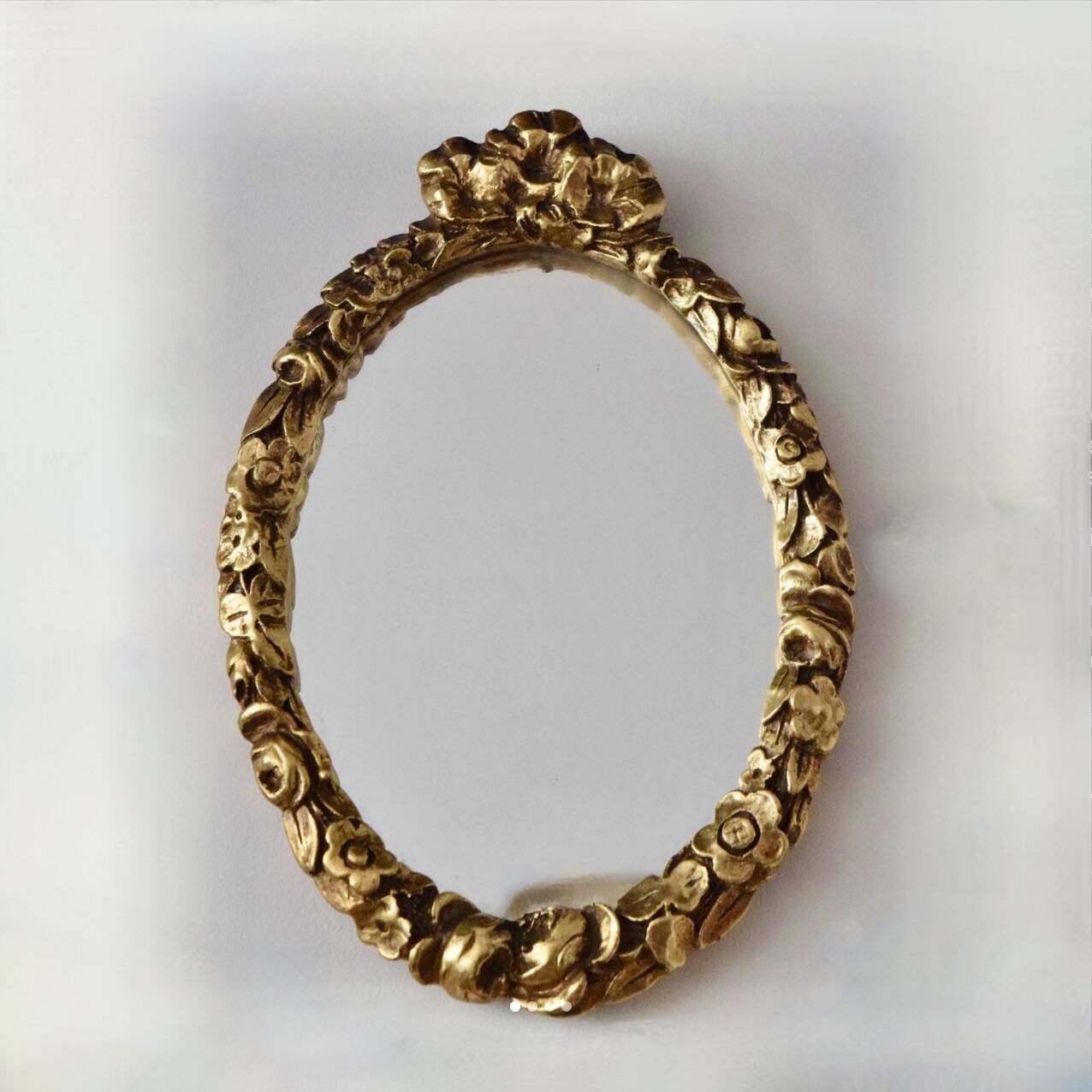 Small vintage oval wall mirror in varnished gold resin