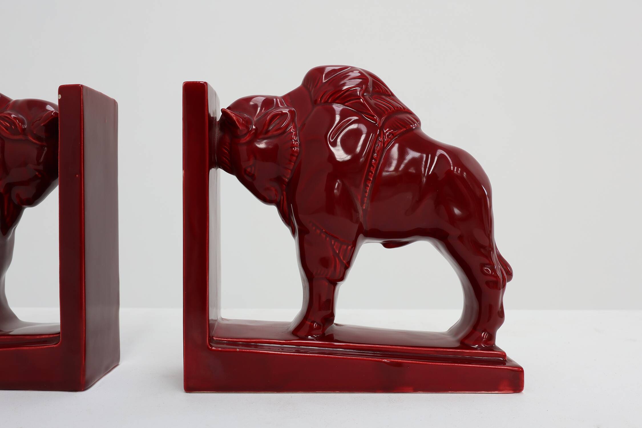 Pair of red glazed ceramic Bison ox bookends in Art Deco style, Belgium