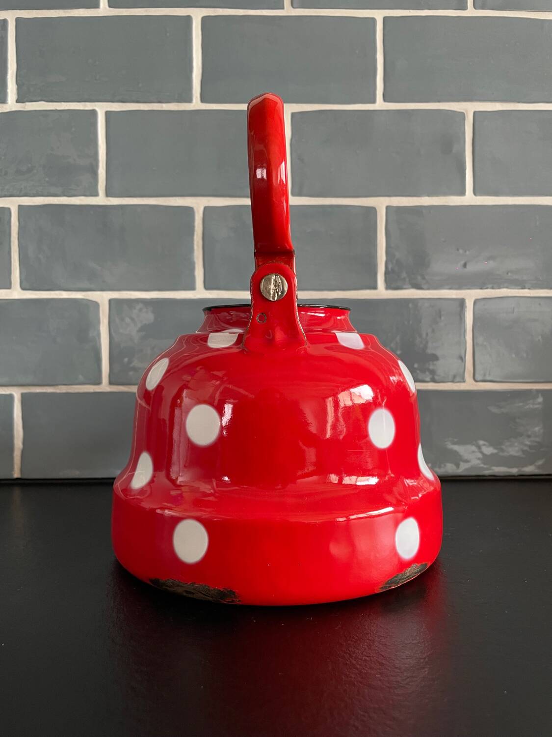 Red enameled sheet metal kettle with white polka dots