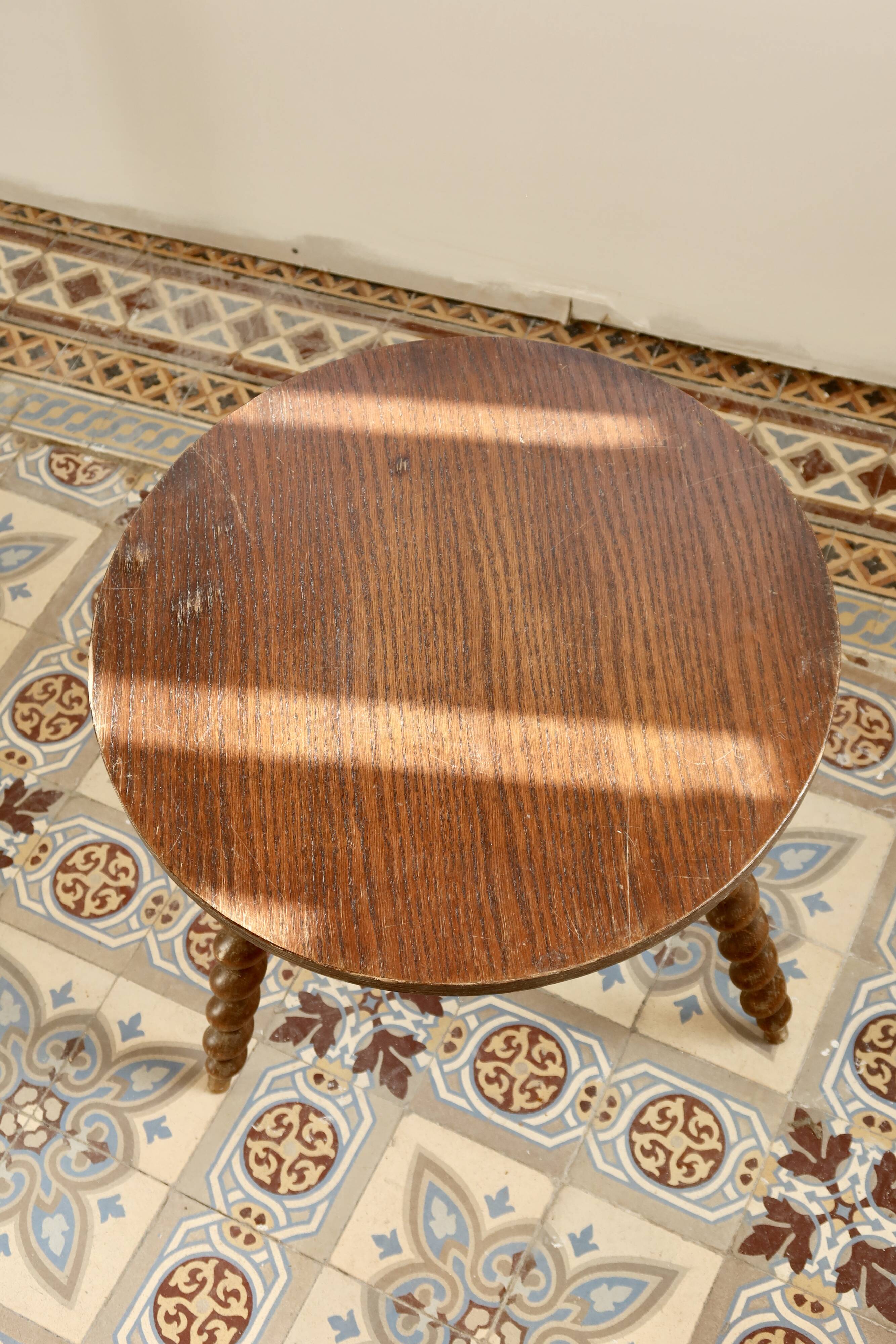 Vintage circular side table in wood with turned legs.