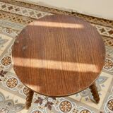 Vintage circular side table in wood with turned legs.