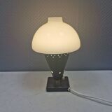 Small stylish table lamp with perforations and milky white opal glass shade