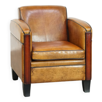 Sheepskin Art Deco design armchair with beautiful wooden details and black piping
