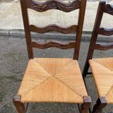2 solid wood chairs with carved rush seats