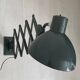 Vintage 1950s green lacquered sheet metal workshop wall light with accordion arm.