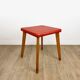 Wooden stool with red faux leather from the 1950s.