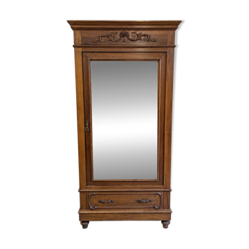 Antique wardrobe with a mirror and carved decorations.