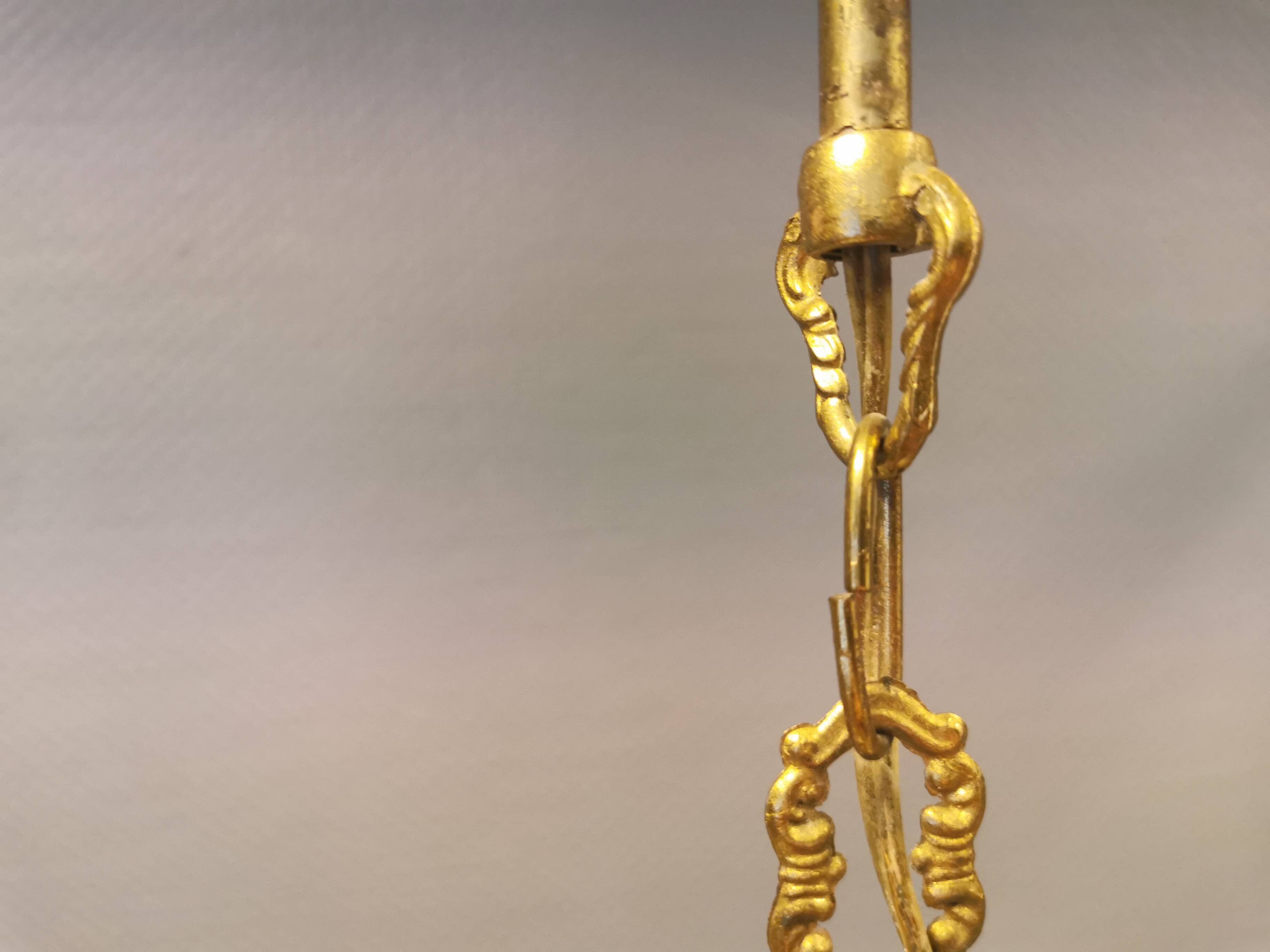 Older brass alloy chandelier with three light sources.