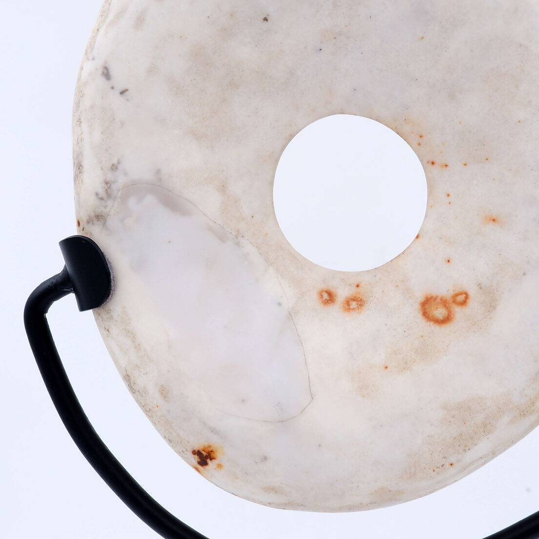 "Wamayuwa" Boiken coin in hand-carved shell mounted on a black metal stand