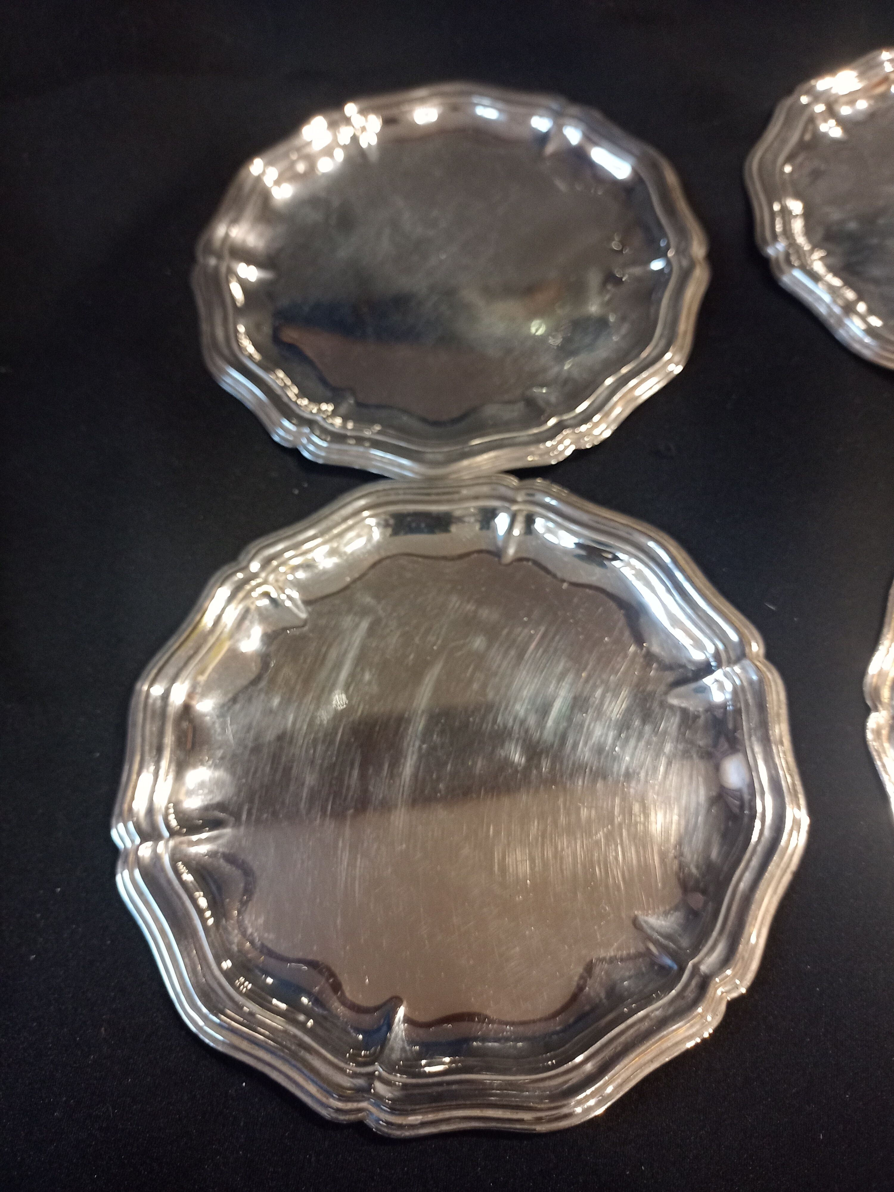 Four silver metal bottle bottoms