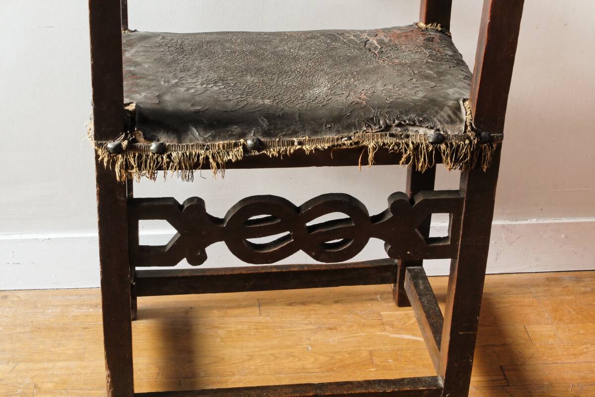 Antique armchair in walnut and studded leather, 17th century