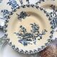 10 mismatched vintage soup plates in blue, green, and red ironstone