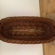 Vintage brown wicker baguette basket, elongated shape, with integrated handles.